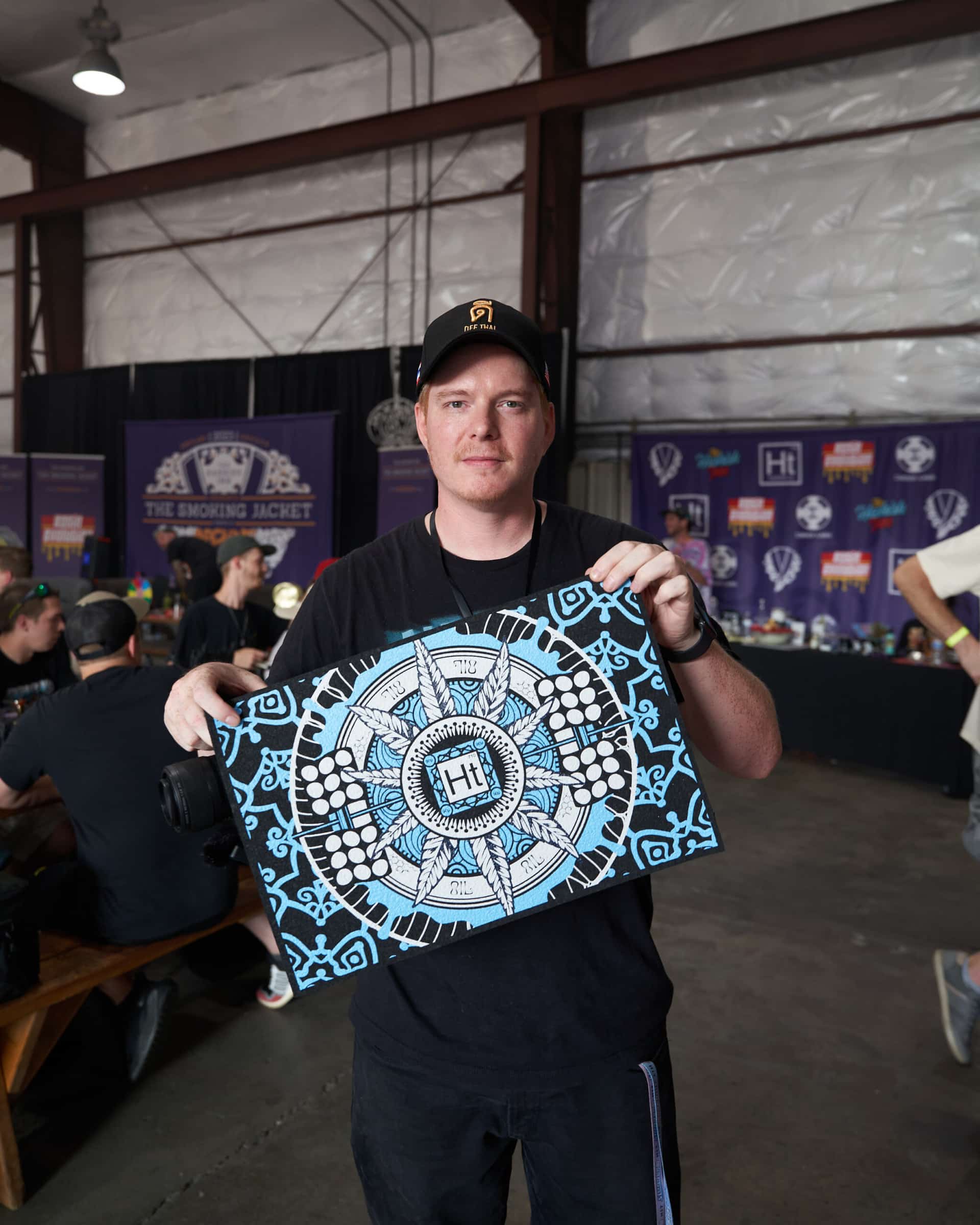 An attendee holding Hashtek artwork on the floor of The Smoking Jacket 2023