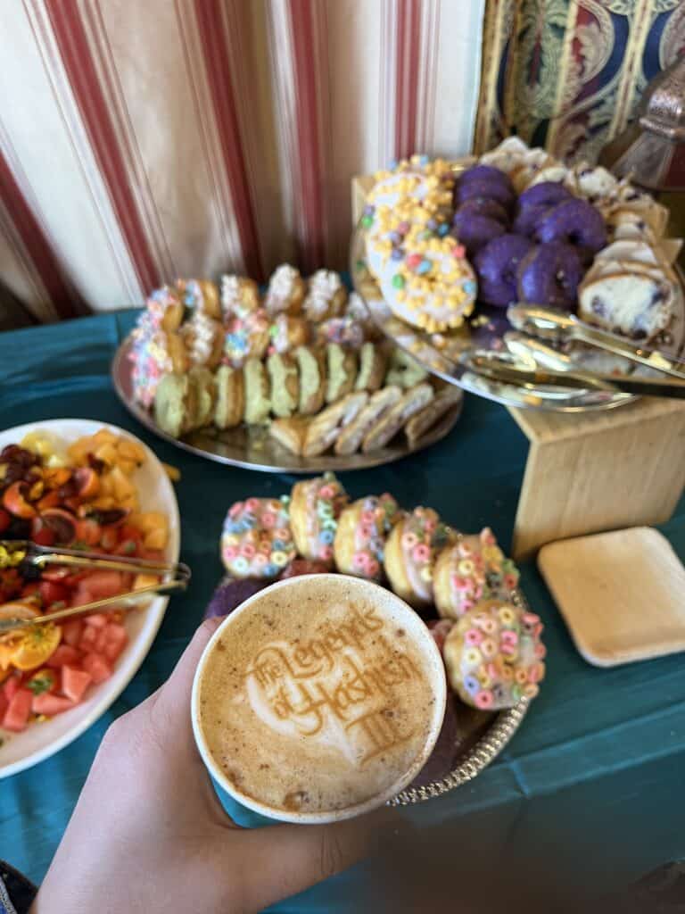 A Legends of Hashish III latte beside a spread of donuts and pastries